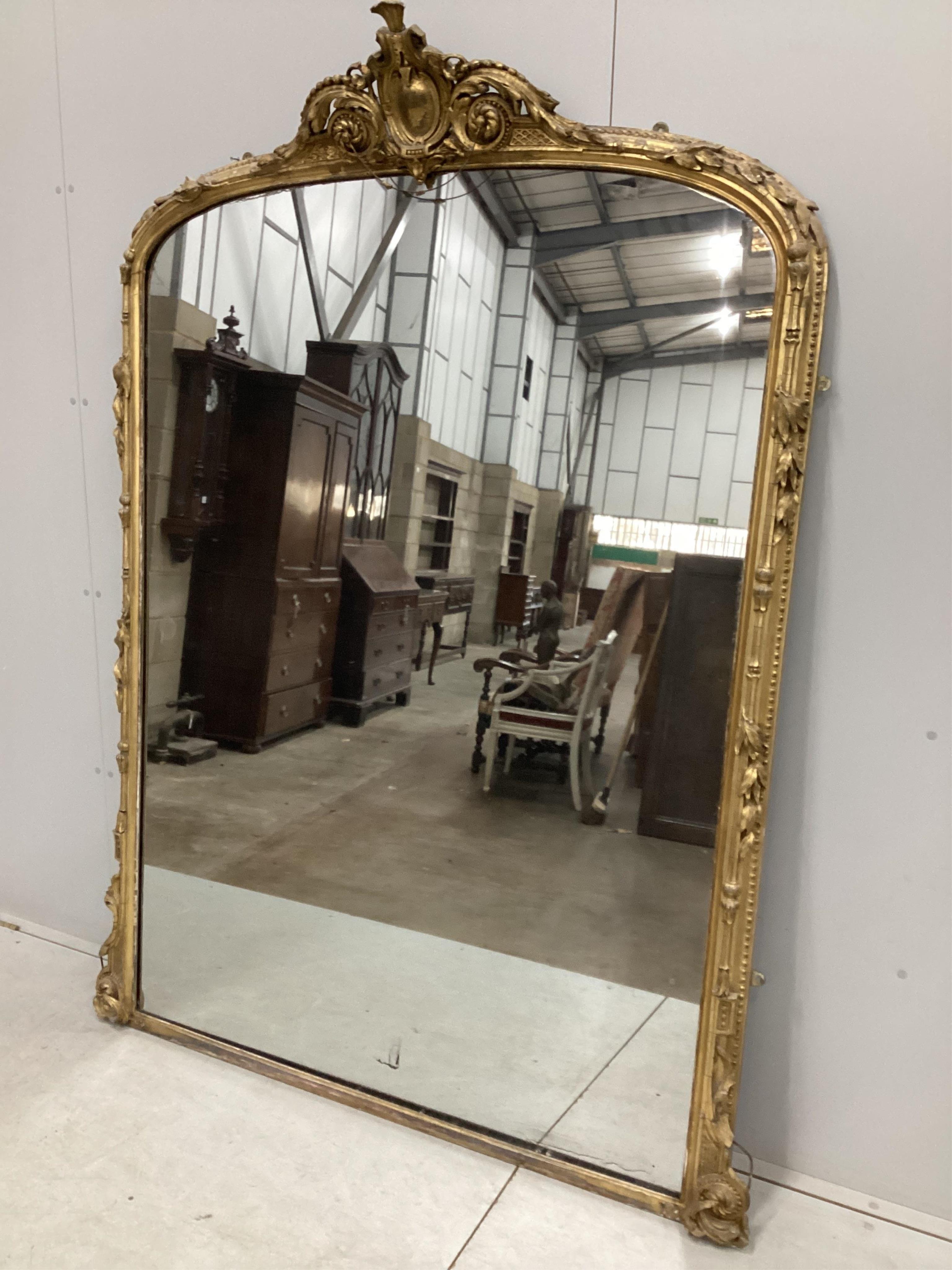 A Victorian giltwood and composition overmantel mirror with cartouche pediment, width 140cm, height 201cm. Condition - fair, three areas of lost gesso